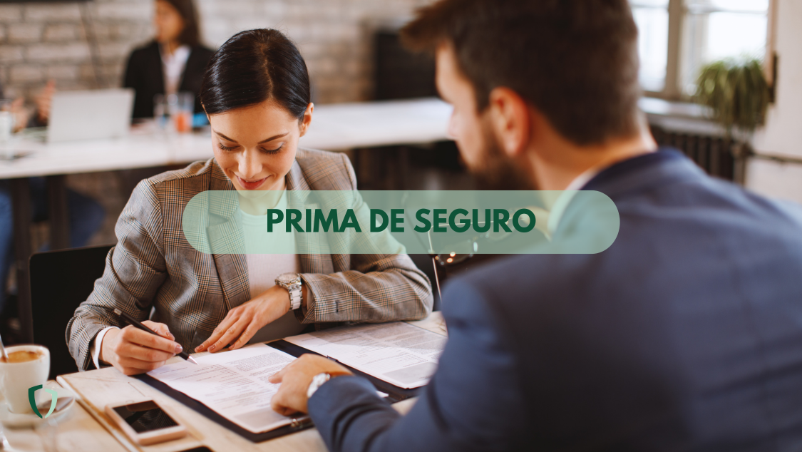 ¿Qué es la prima de seguro? Dos personas formalizando un contrato y leyendo las condiciones